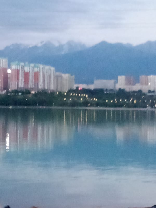 Almaty lakeside promenade under cloudy skies, late afternoon