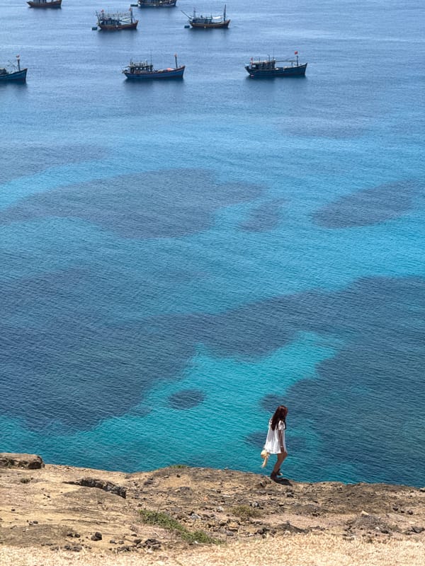 Clifftop views and fishing boats off Lý Sơn Island, Vietnam