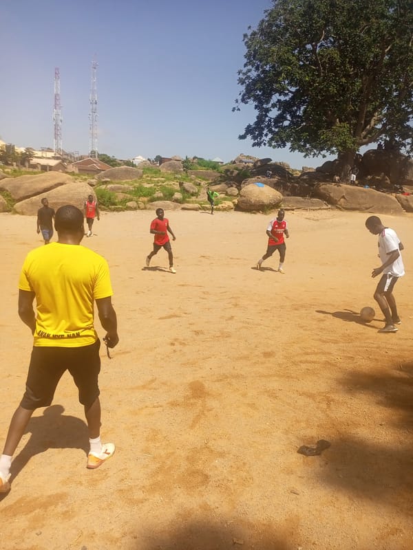Pickup football on a dusty field in Jos, Nigeria.