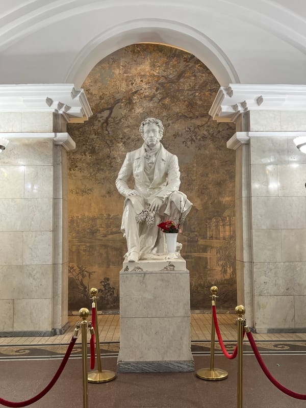 Pushkin statue observed with landscape mural backdrop in Saint Petersburg