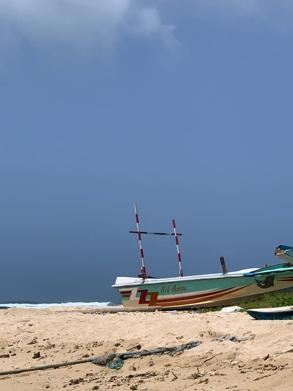Fishing boats and surf culture share the Weligama shoreline