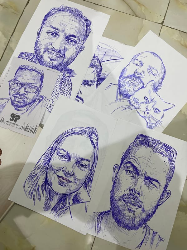 Blue ink portraits and sketches spread across a floor in Abuja