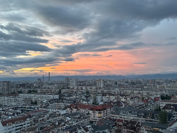 Witness captures dusk cityscape with sunset colors breaking through clouds