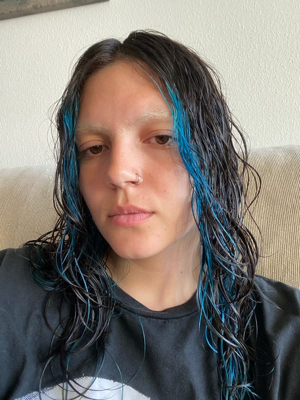 Person documents Friday evening moments in Gijón with blue-streaked hair