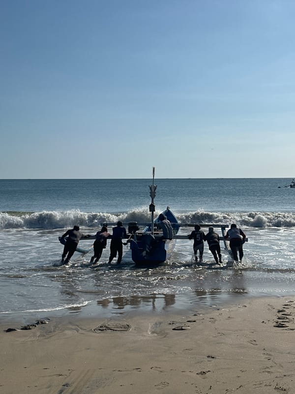 Traditional fishing boats worked through the surf at Kuta Beach