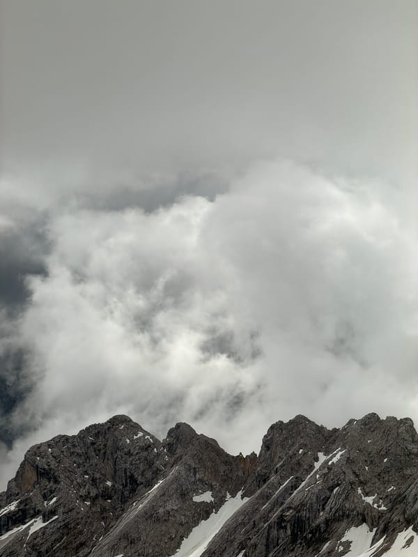 Cloudy mountain landscape with snow patches observed in Austria