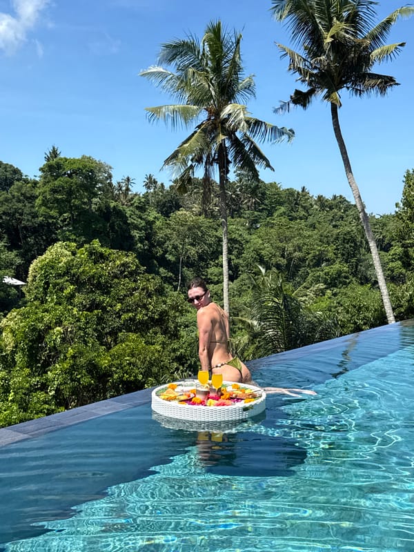 Woman enjoys floating breakfast at Ubud infinity pool