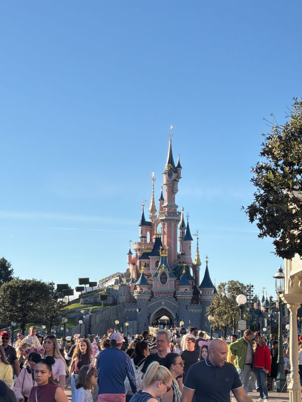 Crowds gather at Disneyland Paris castle under clear skies