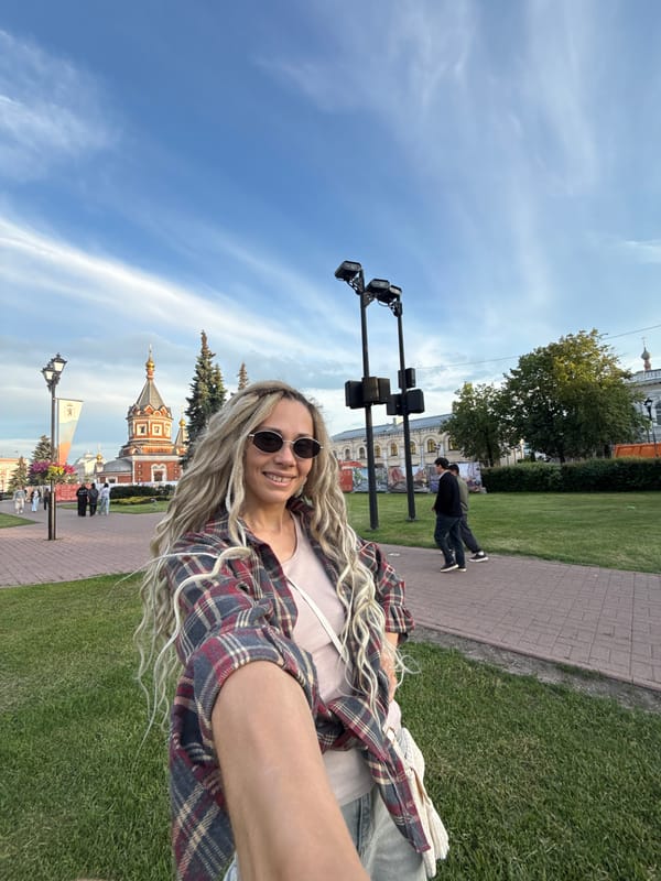 Woman takes outdoor selfies near architectural building