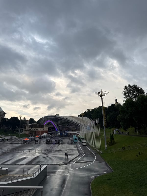 Inside and outside a large stadium venue on a gray day
