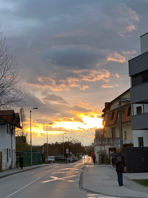 Dramatic sunset illuminates Zagreb street scene with storm clouds