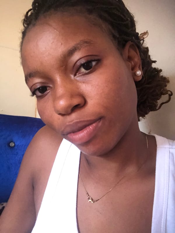 Portrait captured showing person in white top with jewelry