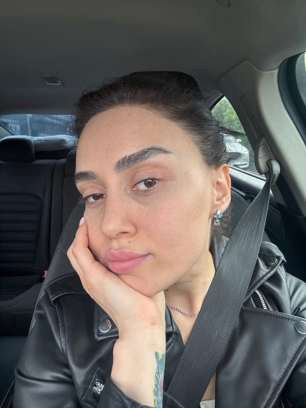 Woman rests in car wearing leather jacket in Tbilisi