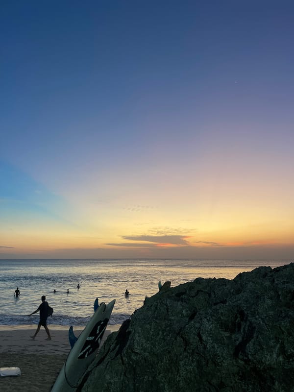 Sunset beach day with surfers and dogs at Kuta Selatan
