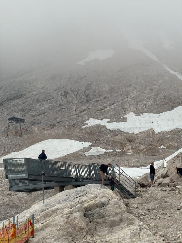 Morning on the Zugspitze: fog, snow patches, and a mountain chapel