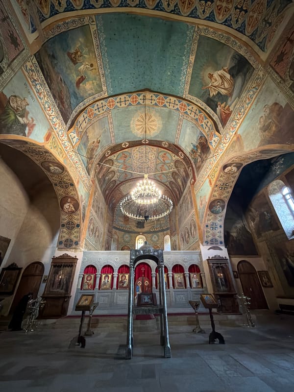 Ornate church interior with painted vaulted ceiling and chandelier