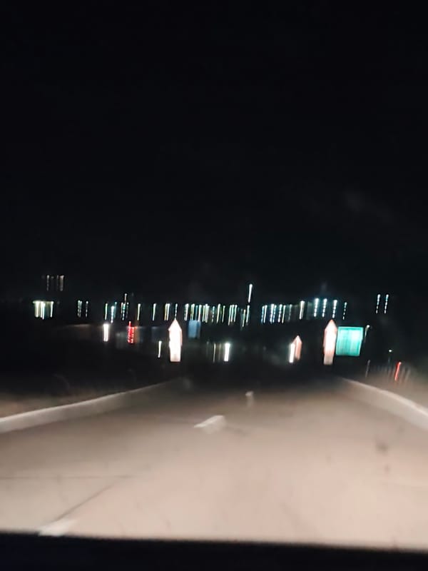 Nighttime vehicle travel captures distant lights near Bulgarian waterway