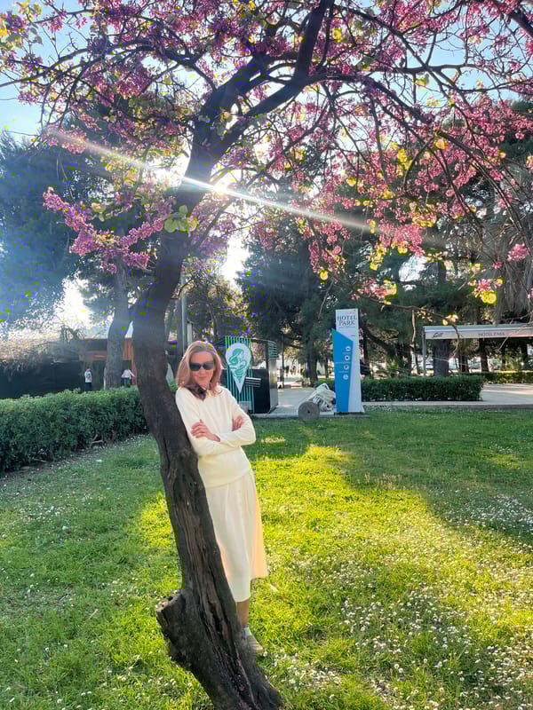 Woman rests on flowering tree branch in Montenegro park