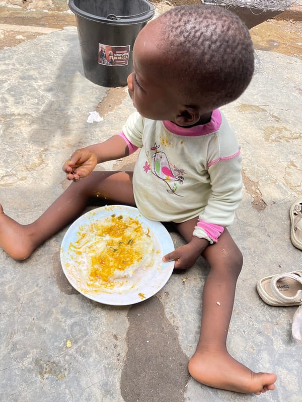 Child enjoys outdoor meal in Nyanya, Nigeria