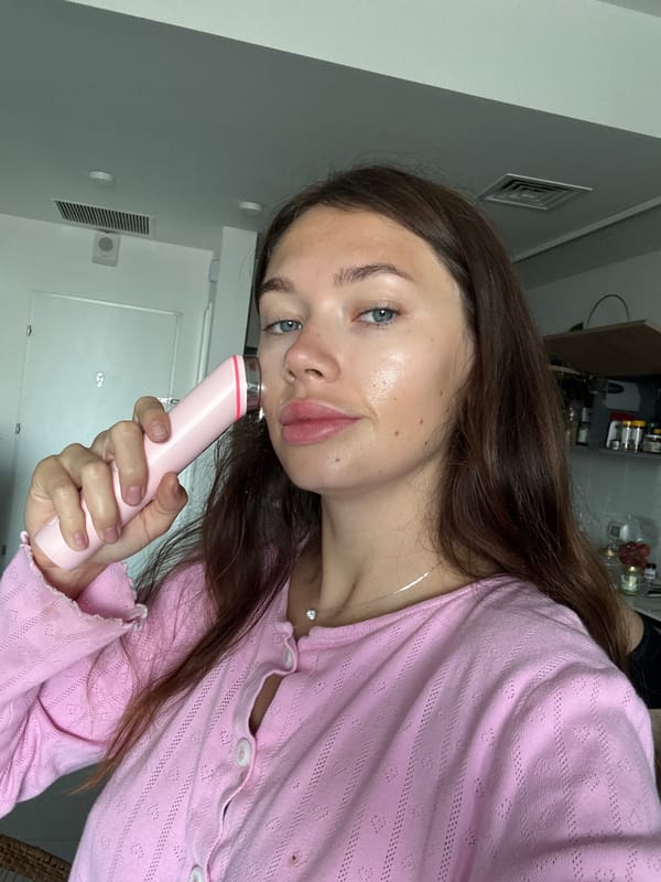 Woman uses pink facial device in Tel Aviv room