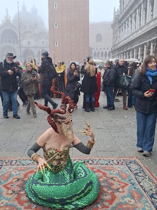 Costumed revelers gather in foggy Venice squares during afternoon