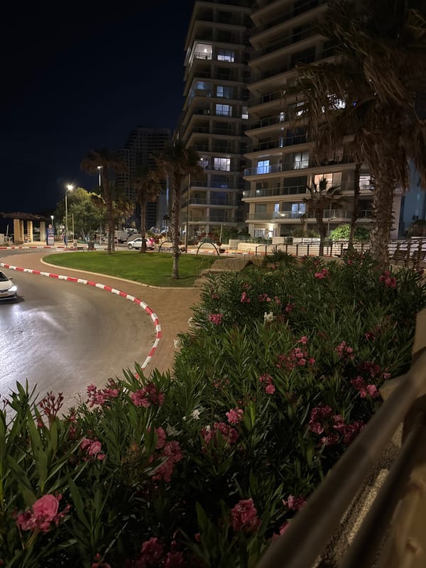Family evening stroll documented along Netanya's illuminated coastal promenade