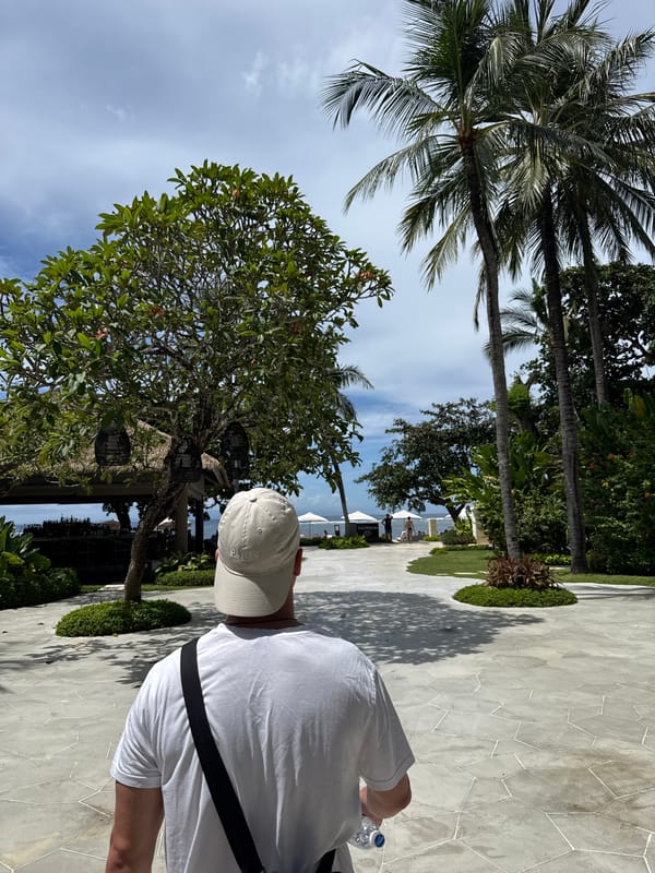 Tourist walks through resort areas in Kuta Selatan morning