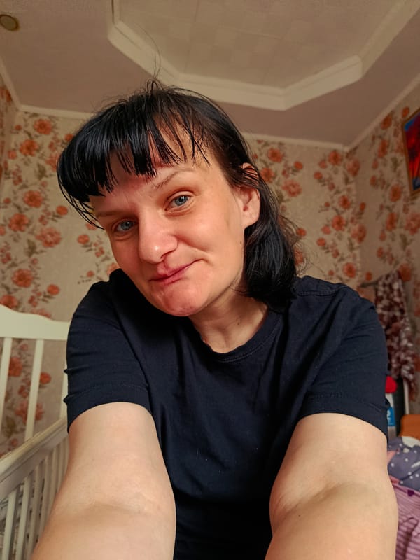 Woman takes selfie with blue eyes and bangs