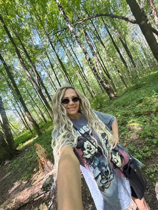 Woman rests on tree trunk in forest setting