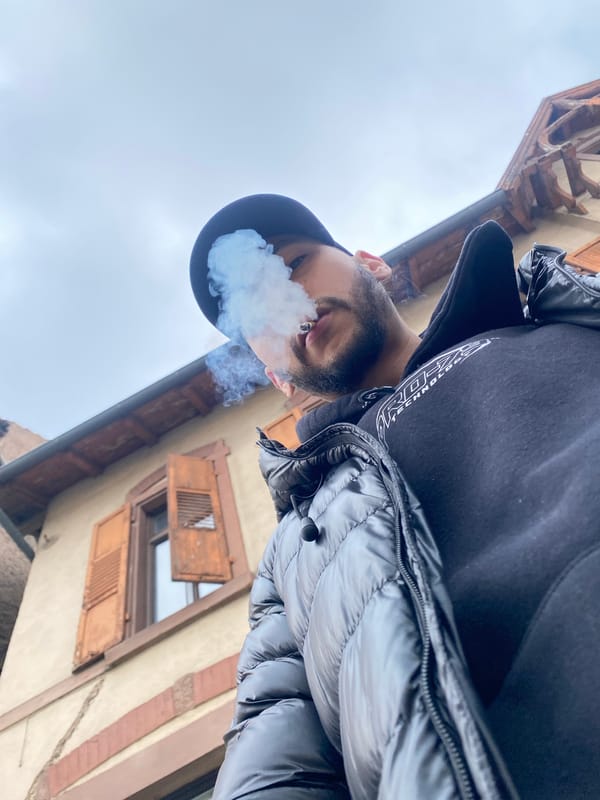 Tourist documents metal face sculpture during Bischheim street visit