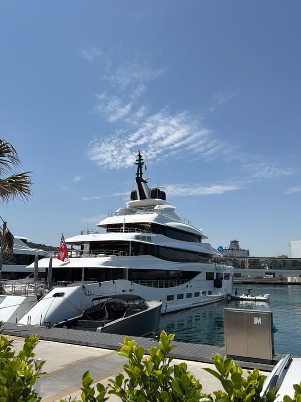 Barcelona marina superyachts and city landmarks on sunny morning