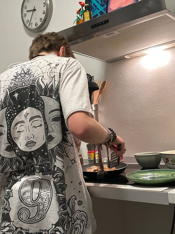 Person cooks dinner in Milan kitchen wearing sun-design shirt