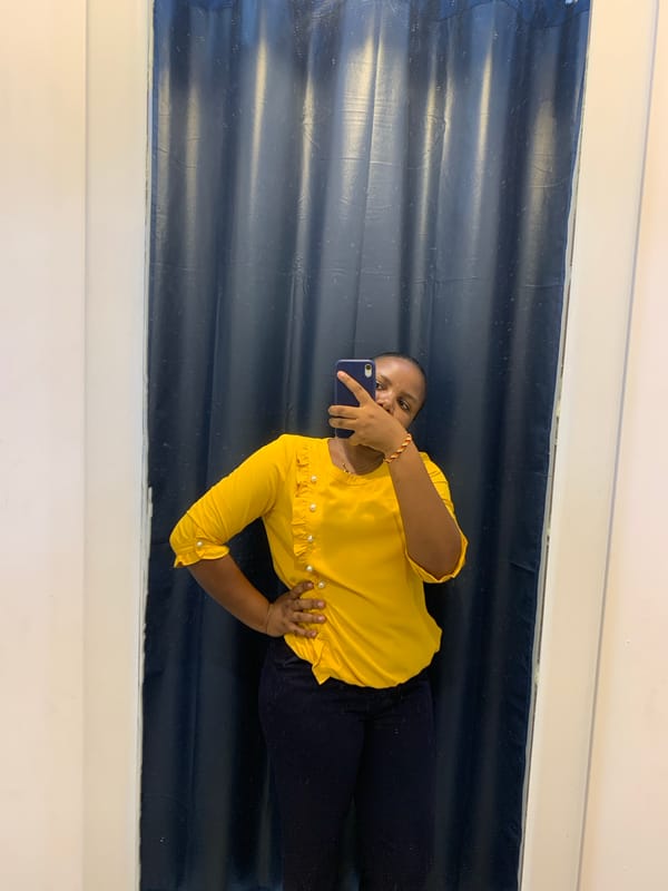 Woman takes selfies in yellow blouse at Dar es-Salaam location