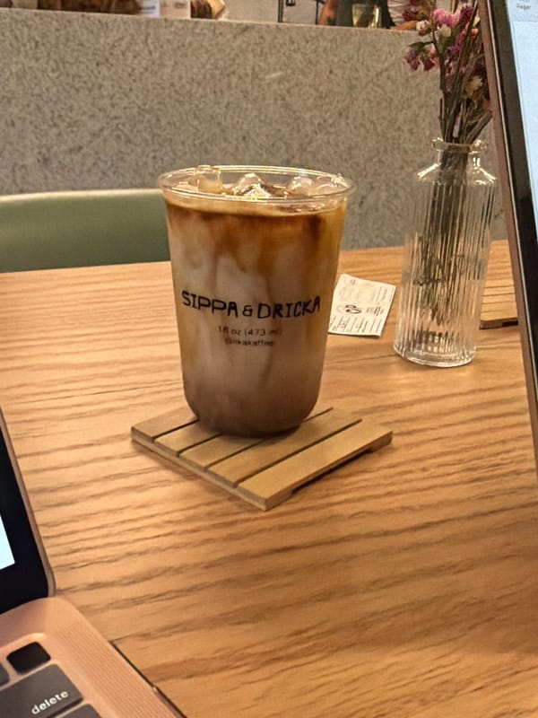 Laptop and iced coffee documented at unidentified cafe location