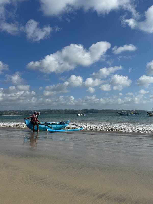 Fishermen launch traditional boats at Kuta Beach, Bali morning