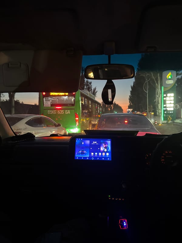Evening drive through Bishkek traffic, dashboard view