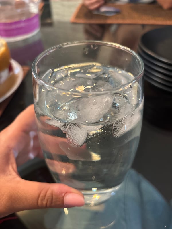 Person enjoys ice water and decorated cake in Puebla kitchen