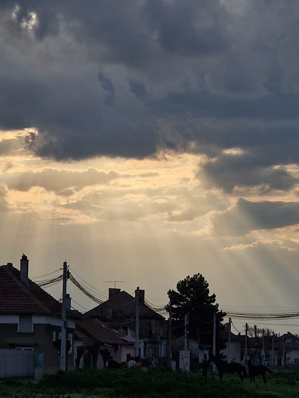 Dramatic sky with dark clouds and sunlight over neighborhood