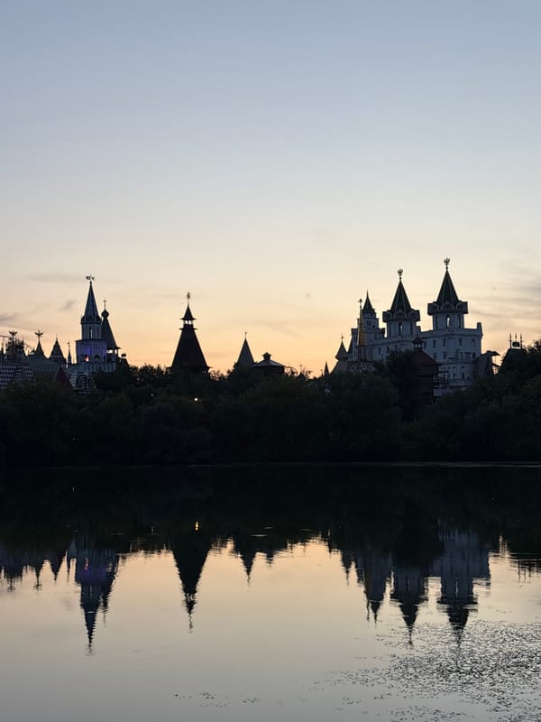 Evening on a Moscow river, towers reflecting and a canoe drifting past