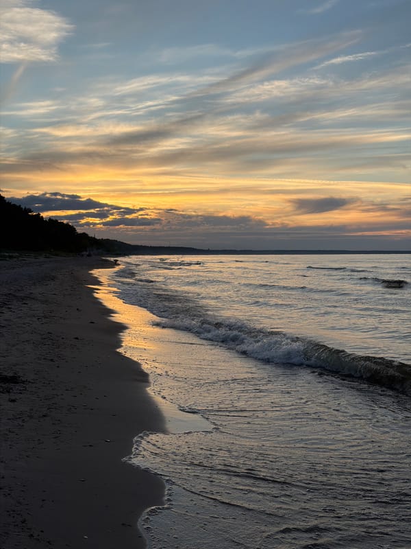 Dusk settles over a dark sand beach in coastal Latvia