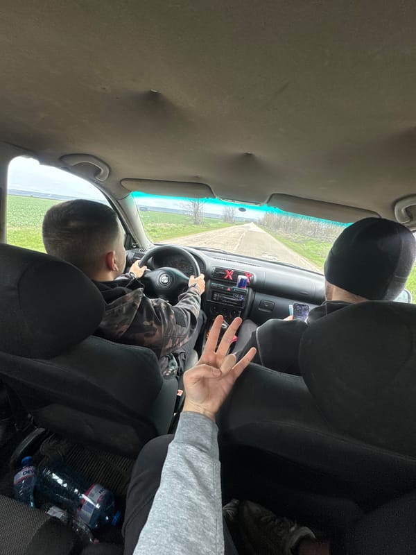 Child sits in driver's seat with adult passenger