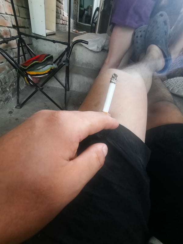 Person photographed smoking cigarette while seated in casual attire