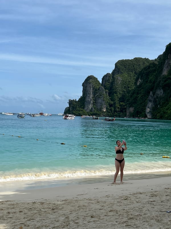Morning beach scene at Ao Nang with tourists and ferry activity