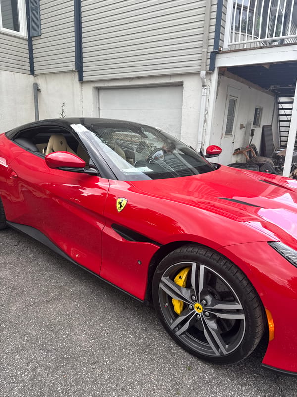 Red Ferrari Portofino parked outside a house, hood up