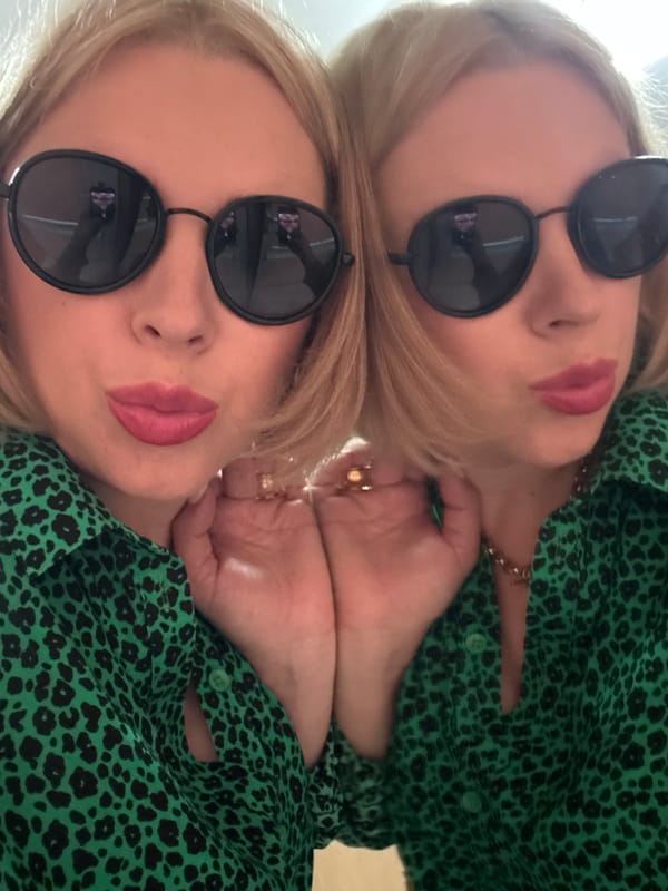 Mirrored selfie reflection in Sochi, sunglasses and green shirt.