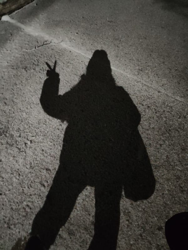 Person leaves footprints, heart drawing, peace sign shadow in snow