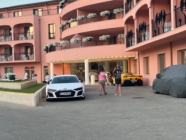 Nesebar beach and streets at dusk, with exotic cars nearby.