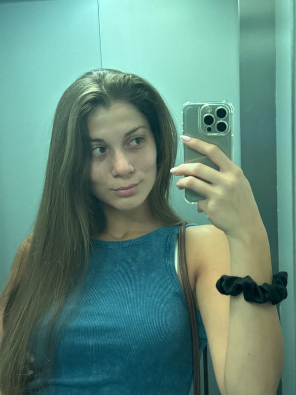 Mirror selfie in a Burgas elevator, blue top and denim.