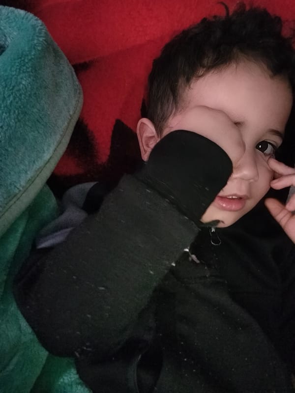 Child rests in sunlit room in Ouaouizert, Morocco