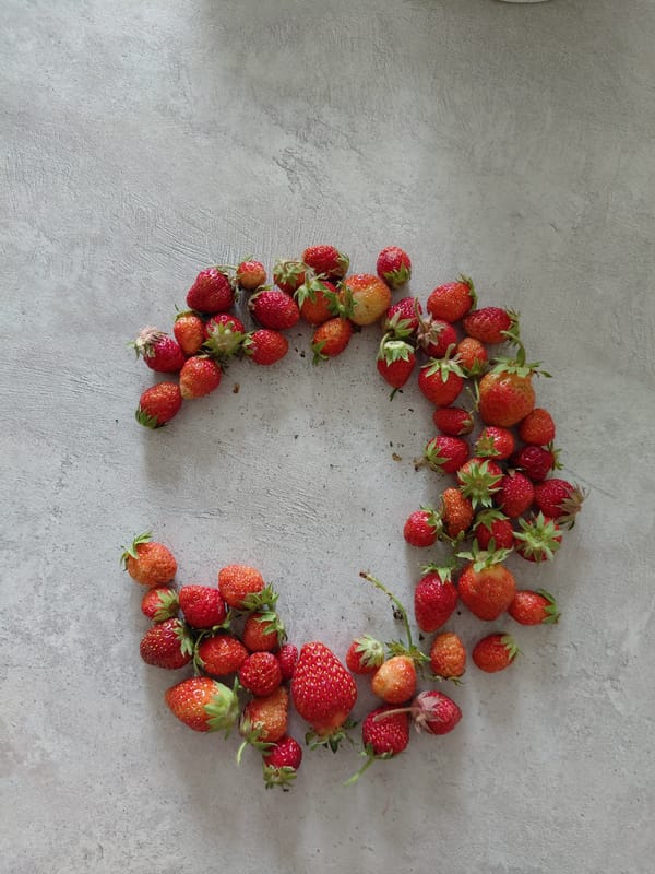 Raffaello chocolates and fresh strawberries styled on a gray surface